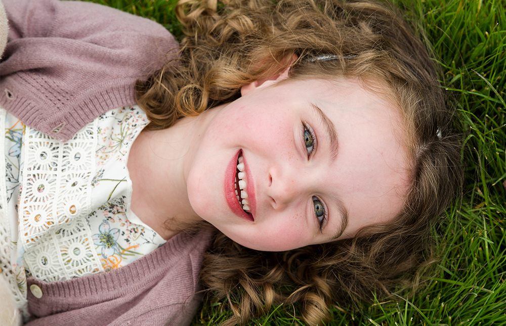 portrait-laying-on-ground-girl-playing-park-child-smile-family-infocus-photography